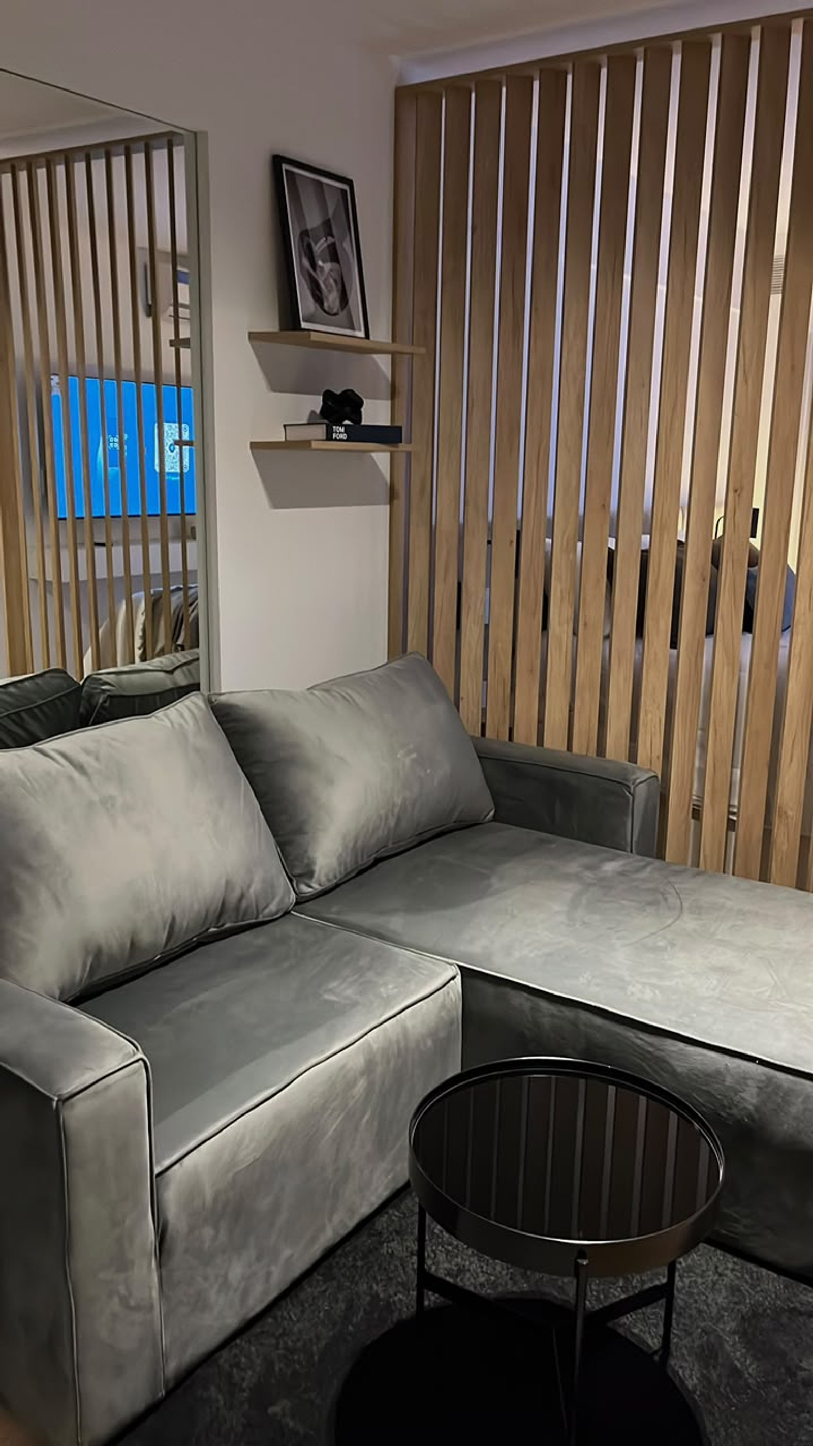 Living moderno con sofá de terciopelo y pared de lamas de madera — proyecto Proyecto Moreno, por Abelina Estudio, en Rosario